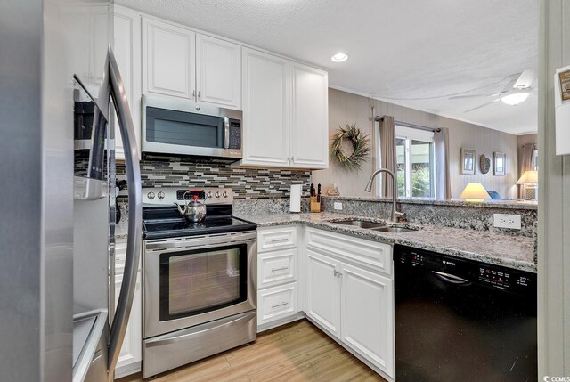 9501 Shore Dr Unit D-132, Myrtle Beach, SC 29572 - kitchen featuring light wood-style flooring, stainless steel appliances, a sink, white cabinets, and tasteful backsplash
