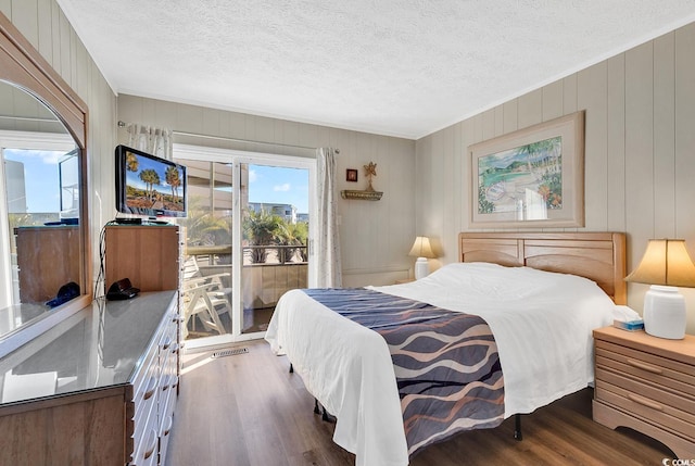 9501 Shore Dr Unit D-132, Myrtle Beach, SC 29572 - bedroom featuring access to exterior, a textured ceiling, and wood finished floors