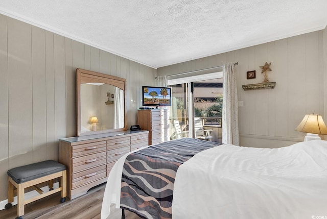 9501 Shore Dr Unit D-132, Myrtle Beach, SC 29572 - bedroom featuring access to exterior, light wood-style flooring, and a textured ceiling