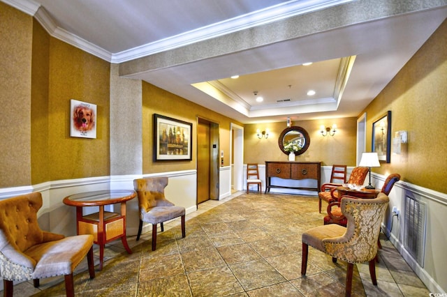 sitting room with a raised ceiling, ornamental molding, recessed lighting, and wainscoting