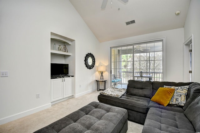 living area featuring visible vents, built in shelves, baseboards, light carpet, and a ceiling fan