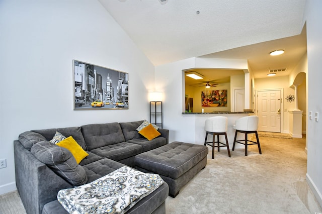 living area with visible vents, baseboards, lofted ceiling, arched walkways, and light colored carpet