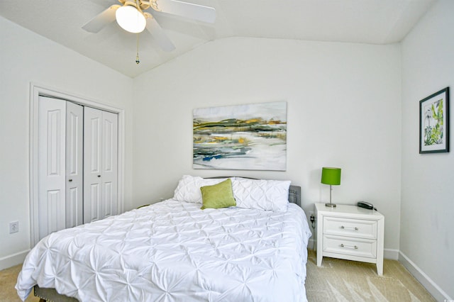 carpeted bedroom featuring a ceiling fan, lofted ceiling, baseboards, and a closet