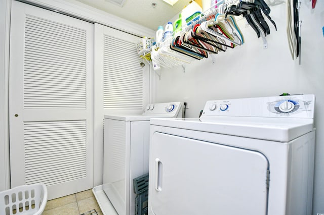 laundry area featuring washing machine and clothes dryer, laundry area, and light tile patterned flooring