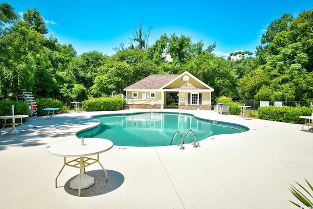 pool with a storage structure, a patio, an outdoor structure, and fence