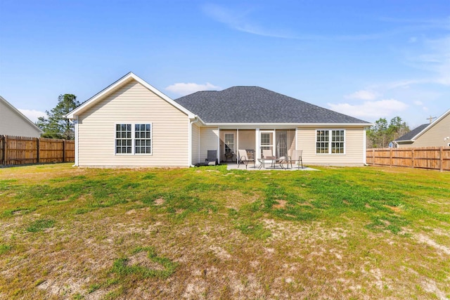 rear view of house featuring a yard, a fenced backyard, and a patio