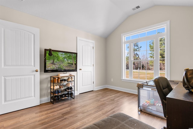 office area with lofted ceiling, baseboards, visible vents, and wood finished floors