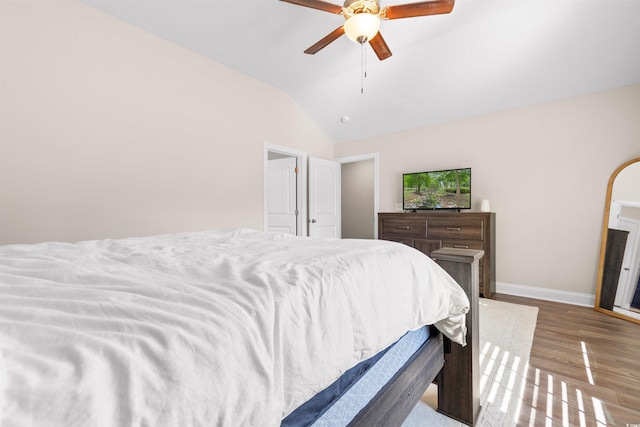 bedroom with lofted ceiling, ceiling fan, wood finished floors, and baseboards