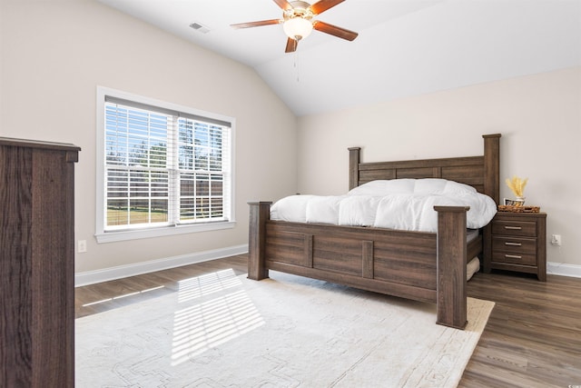 bedroom with lofted ceiling, wood finished floors, a ceiling fan, visible vents, and baseboards