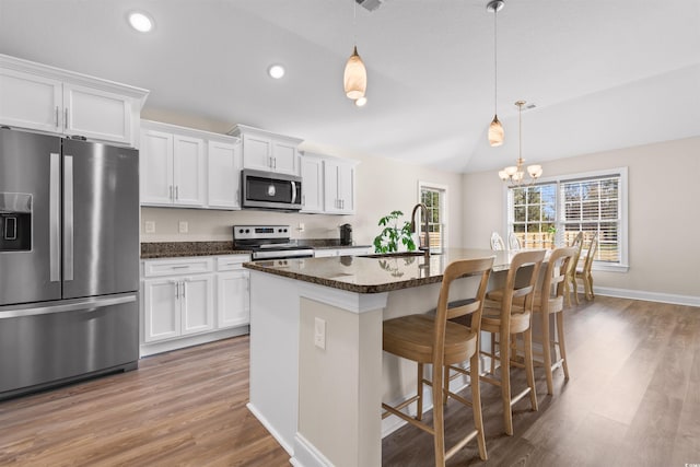 kitchen featuring appliances with stainless steel finishes, a kitchen island with sink, white cabinetry, and a sink