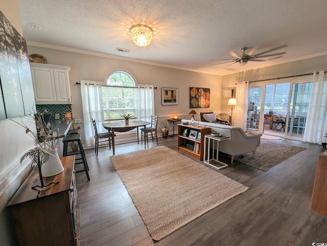 living area with a textured ceiling, visible vents, and dark wood-style flooring