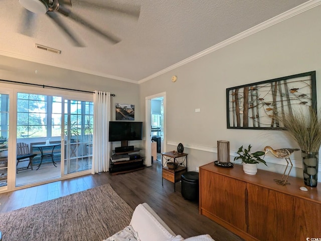 living area with crown molding, dark wood finished floors, visible vents, a ceiling fan, and a textured ceiling