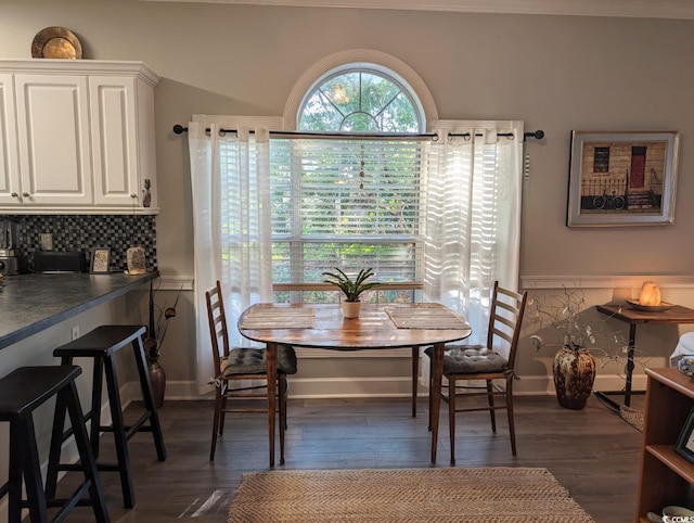 dining area featuring baseboards, breakfast area, and dark wood finished floors