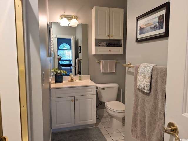 bathroom with baseboards, vanity, toilet, and tile patterned floors