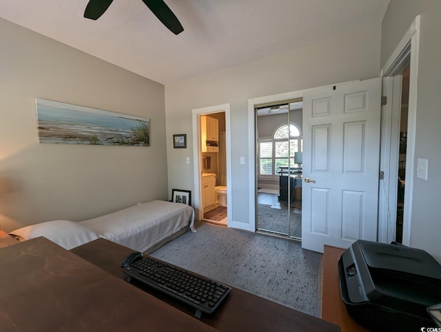 bedroom featuring a textured ceiling, a closet, wood finished floors, and a ceiling fan