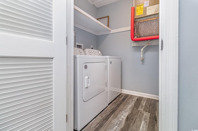 washroom with laundry area, baseboards, washer and clothes dryer, and wood finished floors