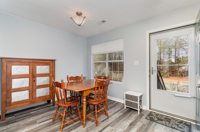 dining room with plenty of natural light, visible vents, and wood finished floors