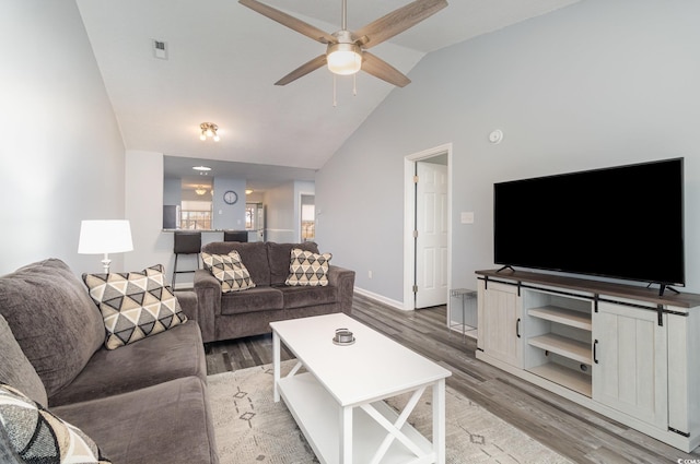 living room featuring visible vents, light wood-style flooring, ceiling fan, high vaulted ceiling, and baseboards