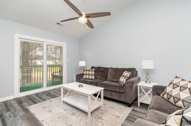 living area featuring lofted ceiling, a textured ceiling, wood finished floors, visible vents, and a ceiling fan