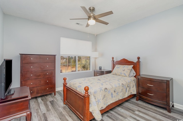 bedroom with a ceiling fan, light wood-type flooring, visible vents, and baseboards