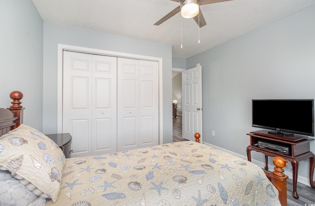 bedroom featuring a textured ceiling, wood finished floors, a ceiling fan, baseboards, and a closet