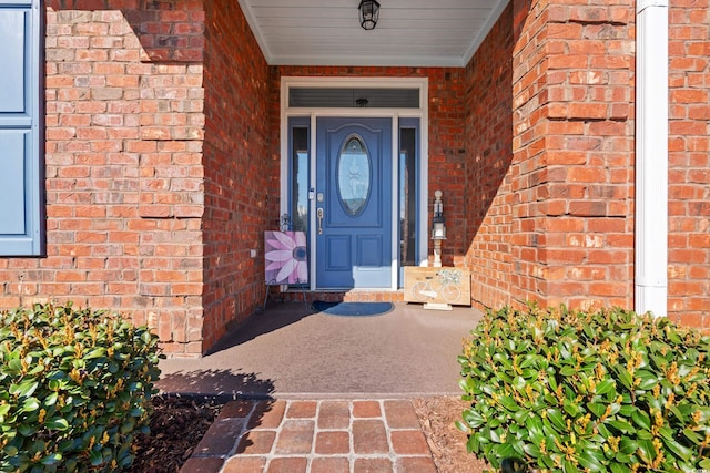 entrance to property featuring brick siding