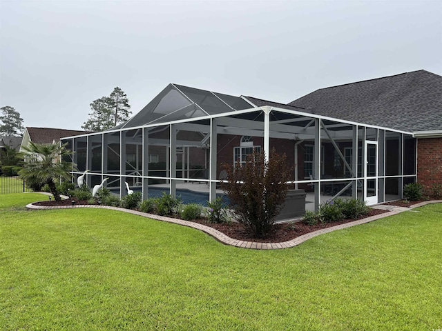 3516 Queens Harbour Blvd, Myrtle Beach, SC 29588 - rear view of house with a yard, roof with shingles, an outdoor pool, and glass enclosure