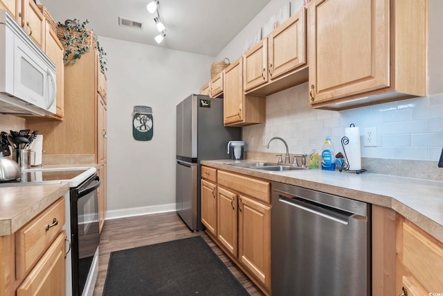 kitchen featuring stainless steel appliances, backsplash, a sink, and light countertops