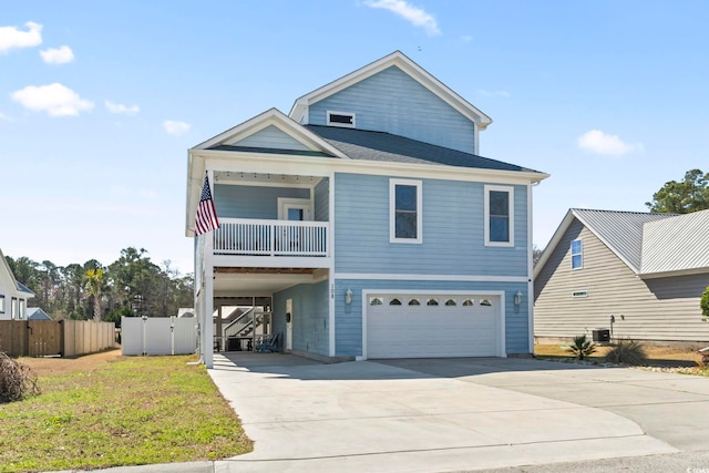 coastal home featuring driveway, a carport, an attached garage, and a balcony