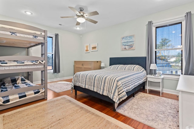 bedroom with a ceiling fan, baseboards, and wood finished floors