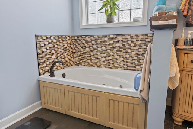 bathroom with a jetted tub, tile patterned flooring, and baseboards