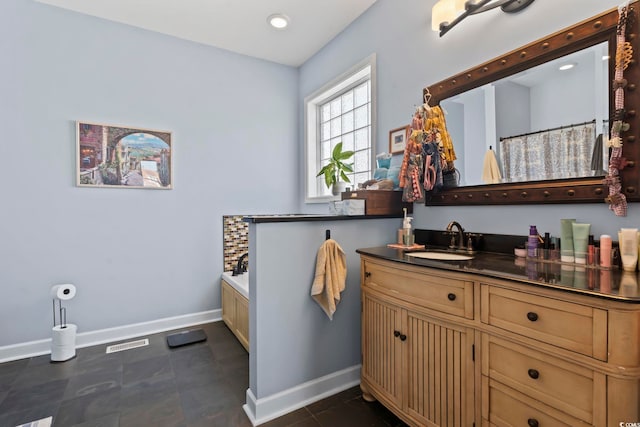 bathroom with a garden tub, visible vents, vanity, tile patterned flooring, and baseboards