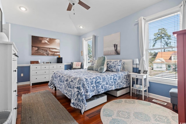 bedroom featuring lofted ceiling, visible vents, a ceiling fan, wood finished floors, and baseboards