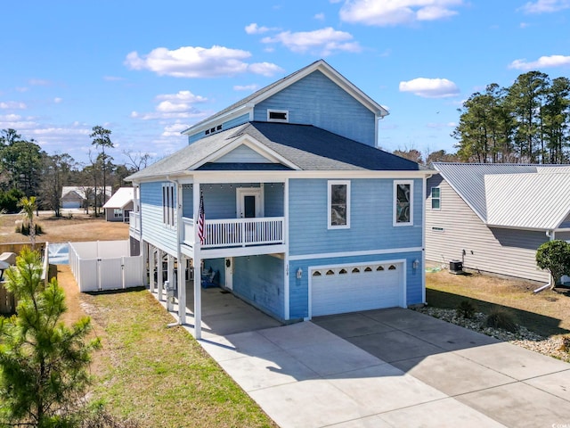 beach home with a shingled roof, concrete driveway, an attached garage, a gate, and cooling unit