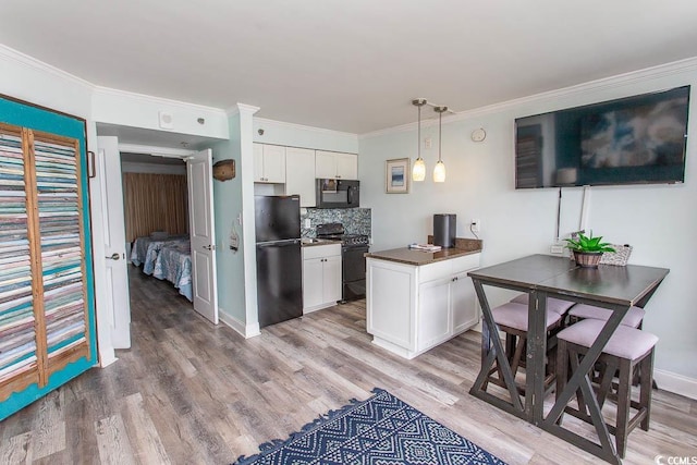 kitchen with light wood-type flooring, black appliances, and white cabinets