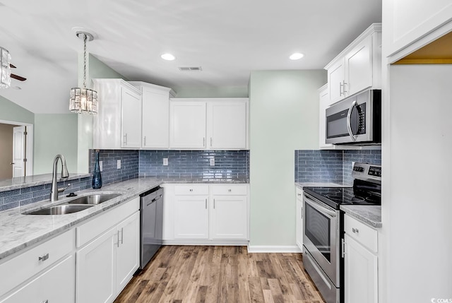 206 Balsa Dr, Longs, SC 29568 - kitchen with stainless steel appliances, white cabinetry, light stone counters, light wood-style flooring, and backsplash