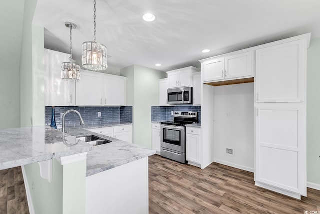 206 Balsa Dr, Longs, SC 29568 - kitchen featuring stainless steel appliances, a peninsula, light stone countertops, white cabinetry, and wood finished floors