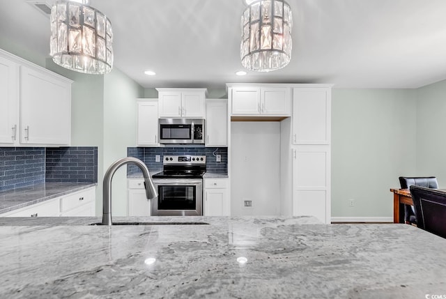 206 Balsa Dr, Longs, SC 29568 - kitchen featuring appliances with stainless steel finishes, a chandelier, light stone countertops, white cabinetry, and recessed lighting