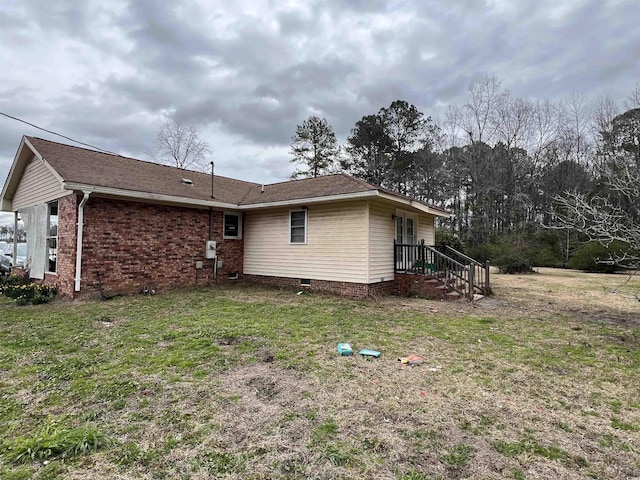 view of side of home featuring a yard and brick siding