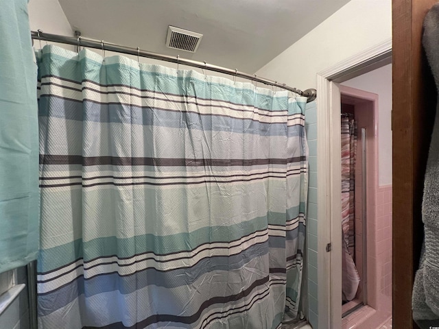 full bathroom with curtained shower and visible vents