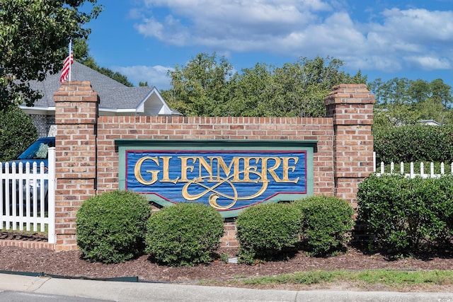 community / neighborhood sign featuring fence