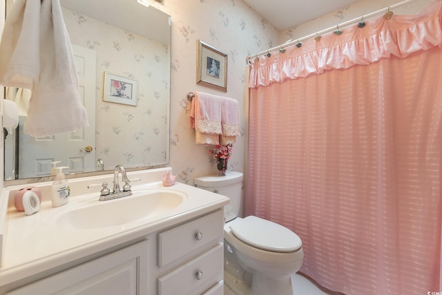 full bath with curtained shower, vanity, toilet, and wallpapered walls