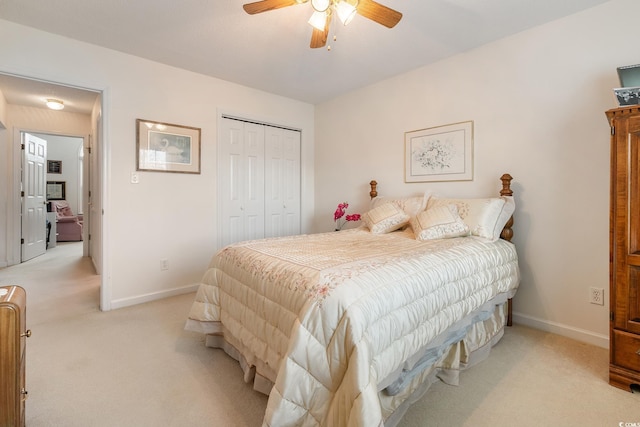 bedroom featuring baseboards, a closet, a ceiling fan, and light colored carpet