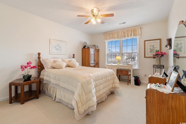 bedroom featuring light colored carpet, ceiling fan, visible vents, and baseboards