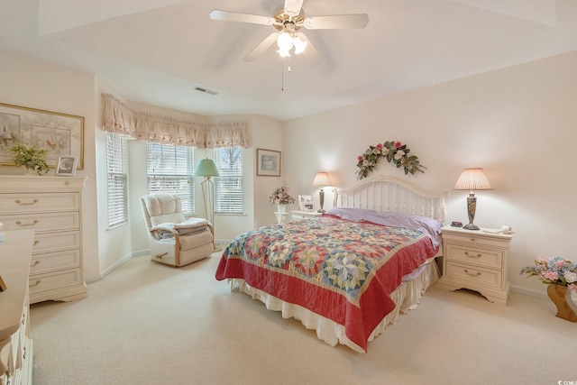 bedroom featuring baseboards, visible vents, a ceiling fan, and light colored carpet