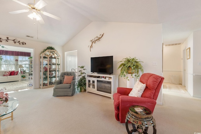 living area featuring carpet floors, visible vents, and vaulted ceiling