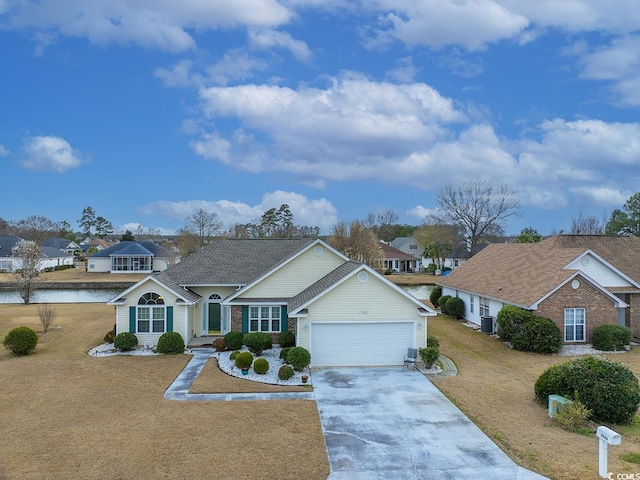 view of front facade with a garage, a residential view, concrete driveway, and a front lawn