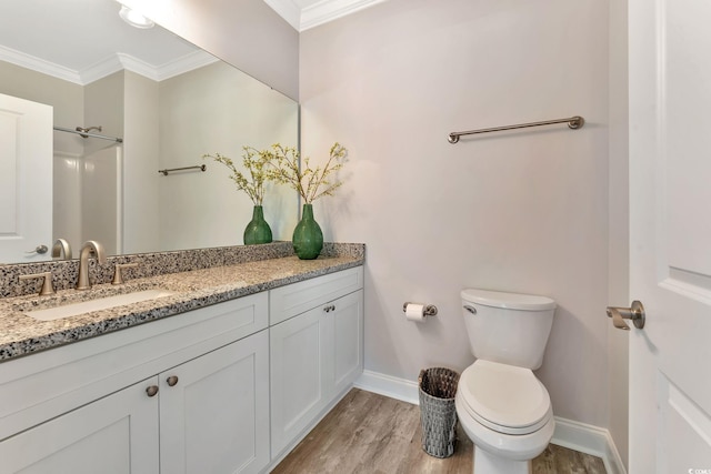 bathroom with ornamental molding, baseboards, toilet, and wood finished floors