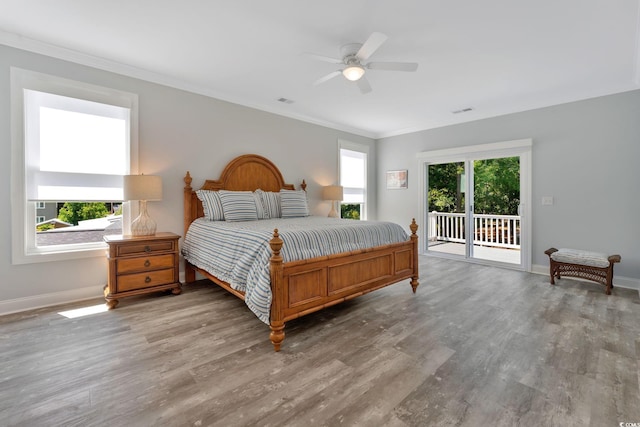 bedroom with access to outside, multiple windows, and wood finished floors