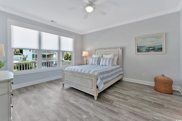 bedroom featuring wood finished floors, visible vents, and crown molding